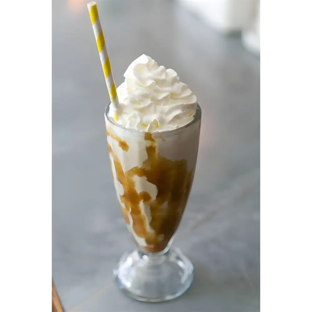 Karamell-Milchshake auf Mix Neutrale Basis Eisbecher mit Schlagsahne und gelb gestreiftem Strohhalm